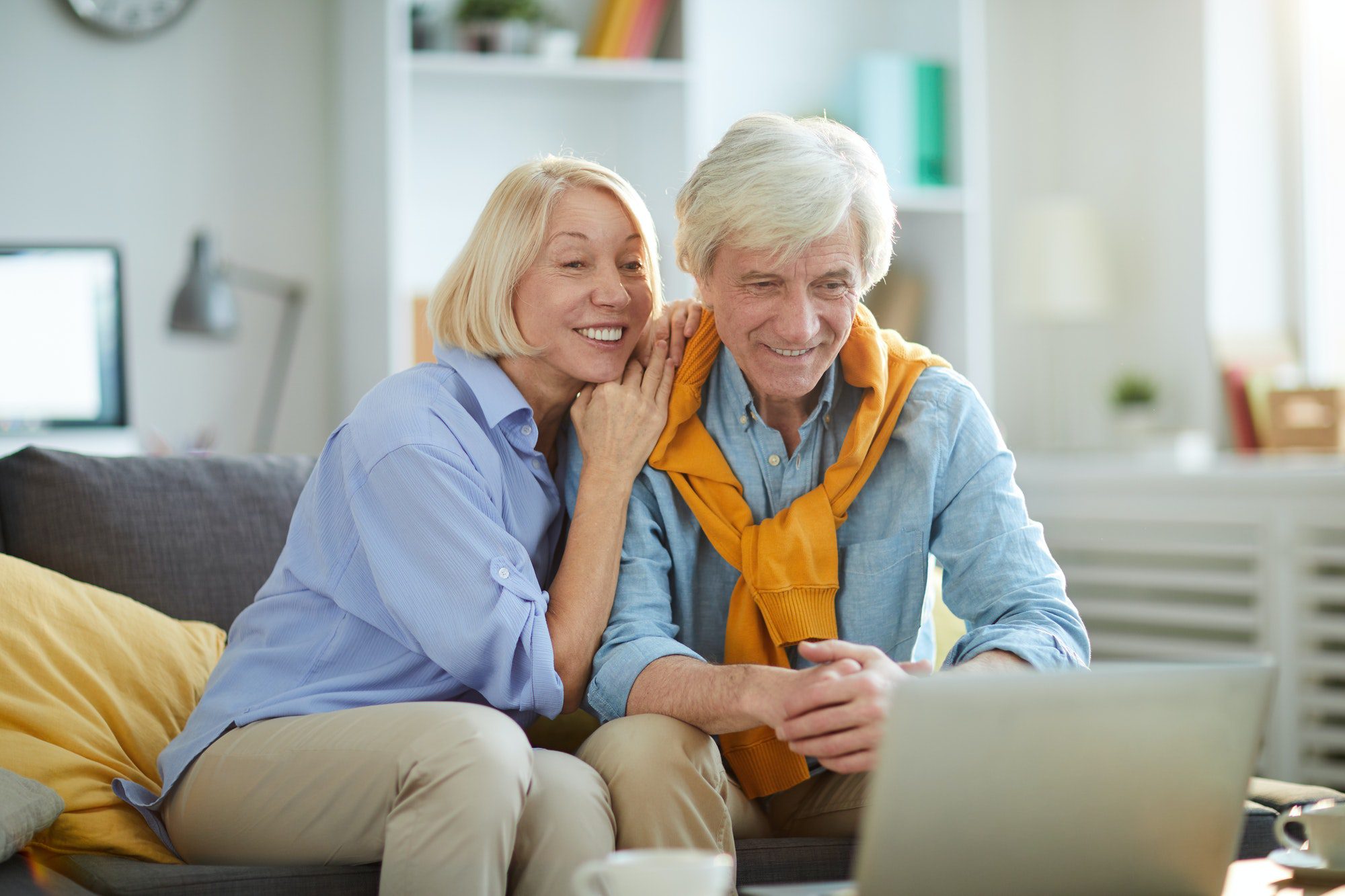 Happy Senior Couple at Home doing research on which Medicare Supplemental policies are core benefits.
